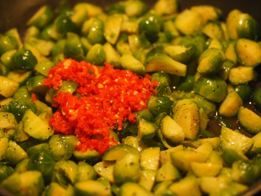 Bilde av stekt rosenkål som nå tilsettes chili