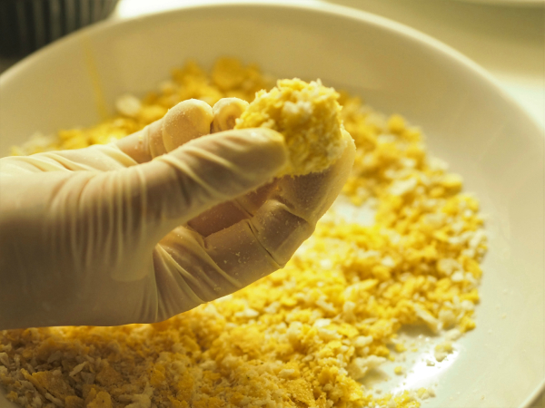 Bilde av chili cheese som blir rullet i bread crumbs