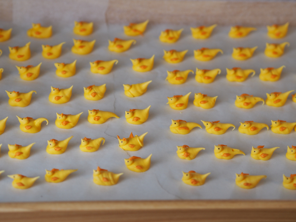 Kakepynt av royal icing. små påskeyllinger ferdig på et brett.