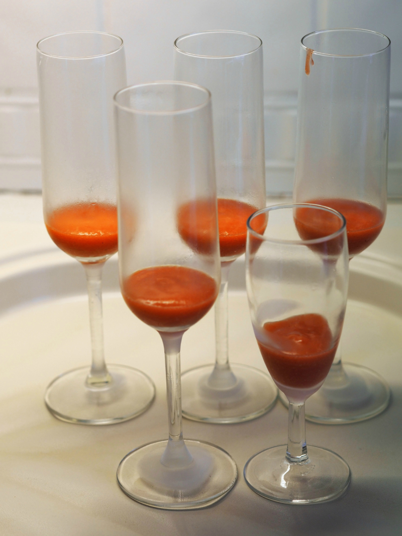 bilde av den perfekte velkomstdrink, bellini i glass før mousserende helles i