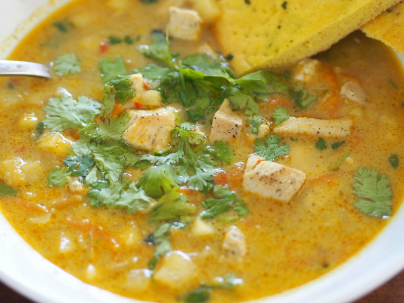 Bilde av deilig kylingsuppe med hakket koriander og nanbrød til.