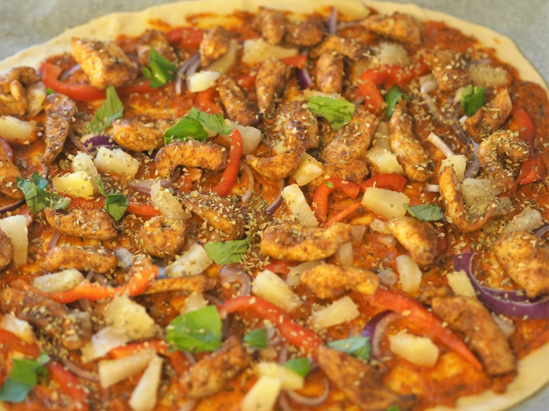 tandoripizza med kylling og grønnsaker klar til steking