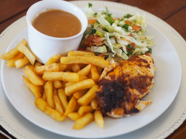 Ferdig servert kylling på boks med salat og pomesfrites.